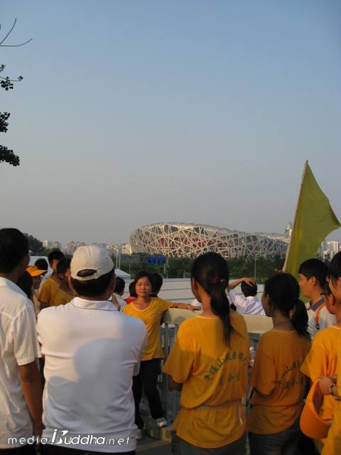 중국 응원단 너머 새둥지를 본떠 만든 베이징올림픽 주경기장의 모습이 보인다.